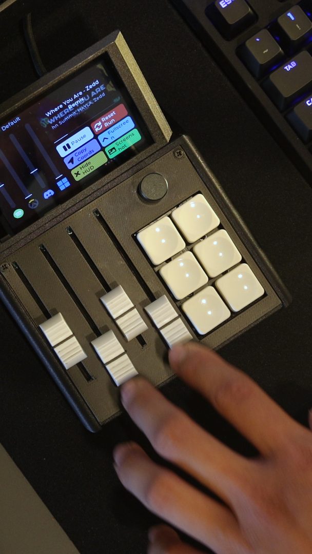 A hand working across the physical faders on the M1X