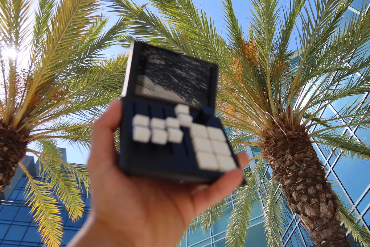 Mixlar M1X held up against palm trees and blue sky